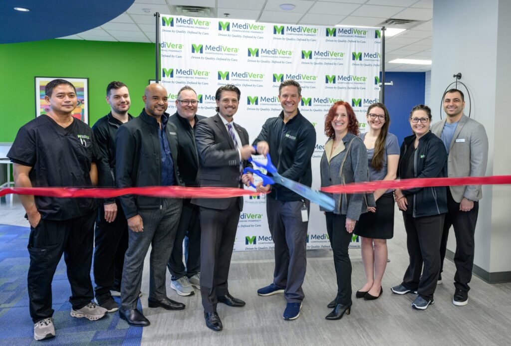 Brad McCloskey cutting the ribbon at MediVera’s grand opening surrounded by staff and chamber members.